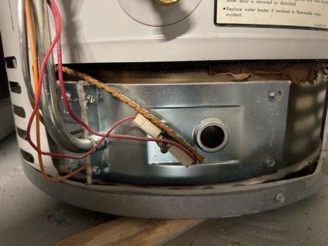 Responded to no hot water condition on tanked water heater. Found pilot light extinguished and valve leaking. Successfully relit pilot light to restore hot water temporarily. Upon inspection, discovered significant corrosion on copper supply lines with heavy green patina and oxidation, indicating advanced age and deterioration of unit. Gas control valve assembly and internal components showing considerable wear. Provided replacement options due to compromised condition of water heater and active leak at valve.