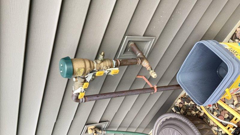 Responded to a water leak on the irrigation line at the main water supply entry point. The leak was identified at a 1" copper tee fitting located before the pressure vacuum breaker (PVB), specifically at the drain plug area of the brass valve assembly, with water dripping every 10-15 seconds. Performed a minor repipe of the copper tee connection to eliminate the leak and restore proper function to the irrigation system.