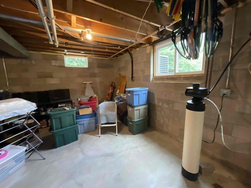 Responded to customer request for water quality assessment. Collected water sample from existing treatment system for laboratory analysis. System consists of water softener unit and blue storage/treatment tank with associated copper piping, pressure gauge, and valve assembly. Observed signs of moisture accumulation on concrete floor near tank base with collection bucket in place beneath plumbing connections, indicating potential minor leak or condensation issue that may require follow-up once lab results are received to determine if additional treatment or system adjustments are needed.