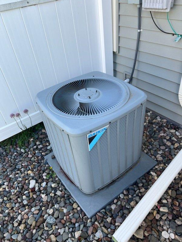Responded to no cooling complaint on an 8-year-old residential air conditioning system. Upon arrival, found the outdoor condenser unit humming but not operating properly with warm copper lines and air blowing from the top of the unit. Diagnosed a failed capacitor preventing proper compressor operation. Verified air filter was clean and condensate drain line was clear. Replaced the defective capacitor and performed condenser coil cleaning to remove accumulated debris. Started the system and verified proper operation with refrigerant pressure testing, measuring approximately 8.5 degrees subcooling which falls within acceptable parameters. Confirmed thermostat communication with equipment and verified adequate airflow from indoor unit. System restored to normal cooling operation.