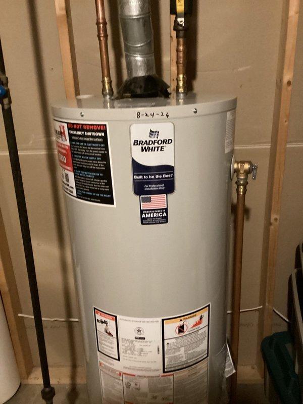 Responded to no hot water complaint and determined the original 40-gallon natural gas water heater had reached end of life and required replacement. Removed existing failed unit and installed new Bradford White 40-gallon natural gas water heater. Connected hot and cold water supply lines with proper brass fittings, installed pressure relief valve with discharge piping, and attached galvanized vent pipe for proper exhaust ventilation. Verified all connections for leaks, tested unit operation, and confirmed hot water delivery. Installation completed in unfinished utility area with all plumbing connections secured and system fully operational.