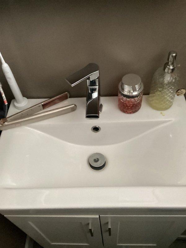 Completed comprehensive plumbing inspection of residential bathroom fixtures as part of family rewards program. Examined sink vanity area including chrome single-handle faucet, drain assembly, and under-sink plumbing connections including supply lines and P-trap configuration. All components found to be functioning properly with no visible leaks or drainage issues detected.