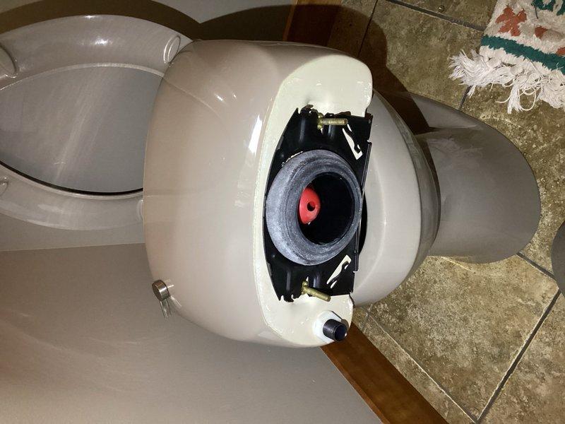 Responded to a reported water leak from the side of a powder bathroom toilet during flushing. Upon inspection, identified a failed tank-to-bowl gasket on a Kohler toilet as the source of the leak. Replaced the defective gasket with a new tank-to-bowl seal and securely tightened all water supply line fittings to ensure proper connections and prevent future leaks.