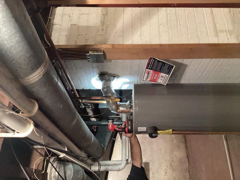 Responded to service call for leaking water heater in residential basement. Upon inspection, found existing 40-gallon standard atmospheric vent water heater actively leaking from bottom of tank, indicating internal tank failure. Unit was still producing hot water but leak posed risk of water damage and complete failure. Evaluated installation location, existing venting configuration, and utility connections. Recommended replacement with 50-gallon power vent water heater to provide increased hot water capacity and improved venting efficiency. Documented existing equipment condition and installation area with photographs for replacement planning. Provided homeowner with replacement options and specifications for upgraded power vent system.