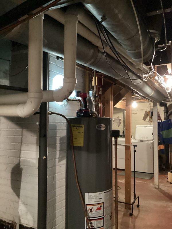 Responded to service call for leaking water heater in residential basement. Upon inspection, found existing 40-gallon standard atmospheric vent water heater actively leaking from bottom of tank, indicating internal tank failure. Unit was still producing hot water but leak posed risk of water damage and complete failure. Evaluated installation location, existing venting configuration, and utility connections. Recommended replacement with 50-gallon power vent water heater to provide increased hot water capacity and improved venting efficiency. Documented existing equipment condition and installation area with photographs for replacement planning. Provided homeowner with replacement options and specifications for upgraded power vent system.
