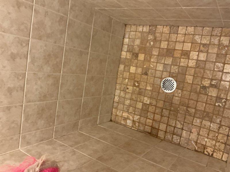 Completed comprehensive plumbing inspection and evaluated water softener system experiencing salt accumulation and water leakage issues. Inspected mechanical room heating system, copper piping network with multiple valves and connections, expansion tank, and pressure tank assembly. Documented shower area with dual tiling patterns and drainage system during inspection process.