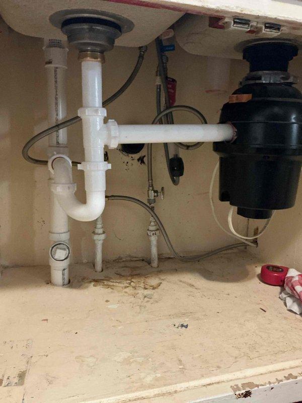 Responded to a leaking kitchen sink drain caused by severely deteriorated galvanized piping. The galvanized pipe connecting the kitchen sink drain to the branch drain had disintegrated and was heavily pitted with rust corrosion. Removed several feet of failed cast iron and galvanized pipe from the basement area. Installed new PVC waste line routed through the bottom of the kitchen sink cabinet, establishing proper connection to the kitchen sink drain and existing drainage system. New installation includes PVC P-trap configuration under double sink basin, ensuring proper drainage and long-term reliability. All affected piping replaced with code-compliant PVC materials to prevent future corrosion issues.