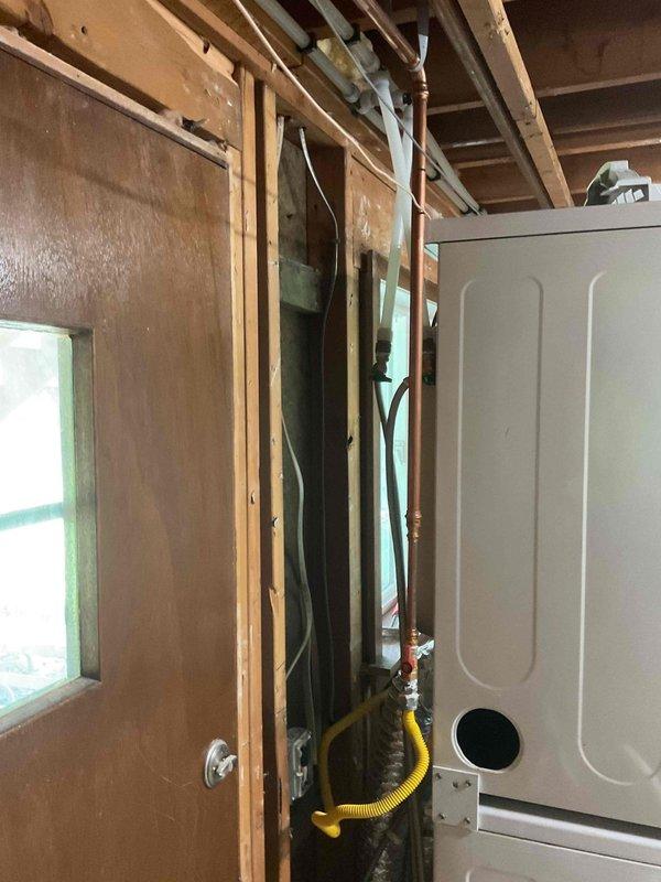 Responded to emergency call for frozen pipe burst that caused basement flooding. Assisted with temporary rough-in plumbing work in affected area, including removal and disposal of damaged existing piping. Performed comprehensive rough-in installation throughout multiple rooms including bathroom, laundry room, and mechanical room. In bathroom, rebuilt vanity drain and DWV system, installed ADA-compliant toilet, and installed customer-supplied tub with shower valve, spout, and head. In laundry area, installed washing machine valve, rebuilt laundry tub drain, and installed deck-mount faucet. In mechanical room, installed freeze-proof hose bibb with up to 15 feet of PEX tubing, installed new water main with shutoffs as required up to 50 feet, and completed associated rough-in work. Pulled baseboard covers in bedroom, laundry room, and bathroom to access work areas. All work completed and inspected per code requirements.