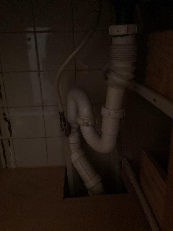 Completed follow-up plumbing work to address previously overlooked bathroom sink venting issue. The bathroom sink drainage system was operating without proper ventilation, which can lead to slow drainage, gurgling sounds, and potential sewer gas infiltration. Installed a studor vent (air admittance valve) under the sink cabinet to provide adequate venting for the drain system. The studor vent was integrated with the existing white PVC P-trap configuration, allowing atmospheric air to enter the drainage system when needed while preventing sewer gases from escaping into the living space. This solution eliminates the need for traditional roof venting and brings the plumbing installation up to proper code standards.