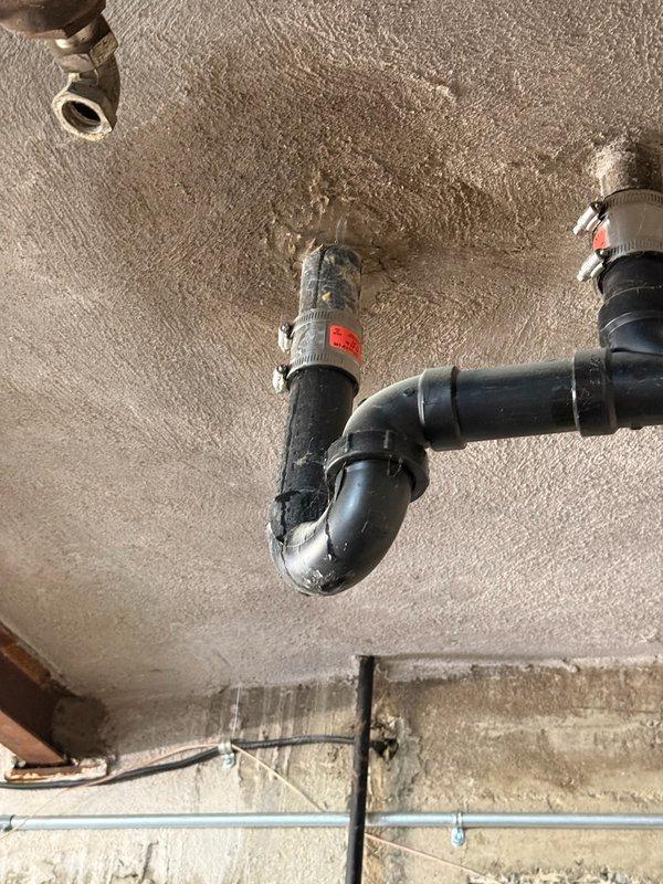 Responded to water leak emergency with water penetrating through garage ceiling from overhead bathtub drain line. Upon investigation, identified severely corroded galvanized pipe section as the source of the leak. Removed the deteriorated galvanized piping and installed new replacement section with proper rubber couplings and stainless steel hose clamps to ensure watertight connections. Verified all connections were secure and tested the drain system to confirm leak was eliminated and proper drainage restored.