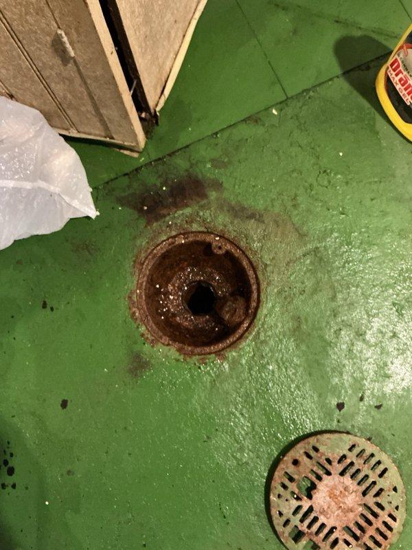Responded to backed up main drain in basement with standing water present in floor drain. Upon arrival, noted that chemical drain cleaner had been previously attempted without success. Vacuumed standing water from floor drain opening and flushed system with high volume of water to clear blockage and restore proper drainage flow.