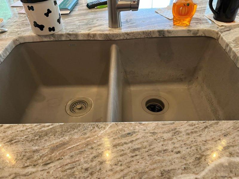 Removed existing garbage disposal unit from double-basin undermount stainless steel kitchen sink. Installed new matching sink strainer basket assembly in place of disposal to eliminate the garbage disposal system. Identified need for matching sink basket for opposite basin to ensure uniform appearance; completed parts order form for procurement and future installation of coordinating strainer assembly.