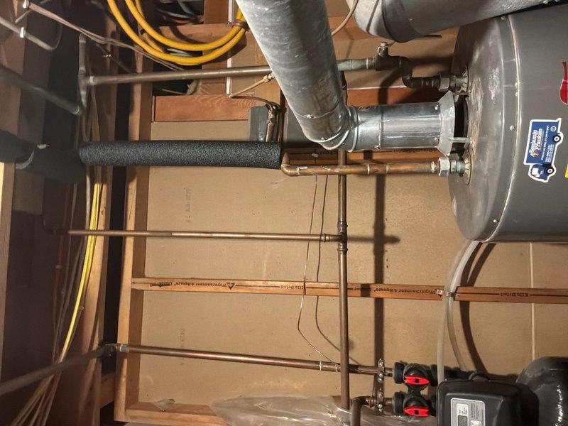 Conducted on-site evaluation of leaking 50-gallon gas water heater showing signs of deterioration at the base. Assessed existing installation proximity to HVAC system and documented current plumbing configuration, electrical panel setup, and utility room layout. Photographed mechanical systems including copper supply lines, shut-off valves, venting, and spatial constraints to provide comprehensive estimate for replacement unit and repositioning to improve clearance from adjacent heating equipment.