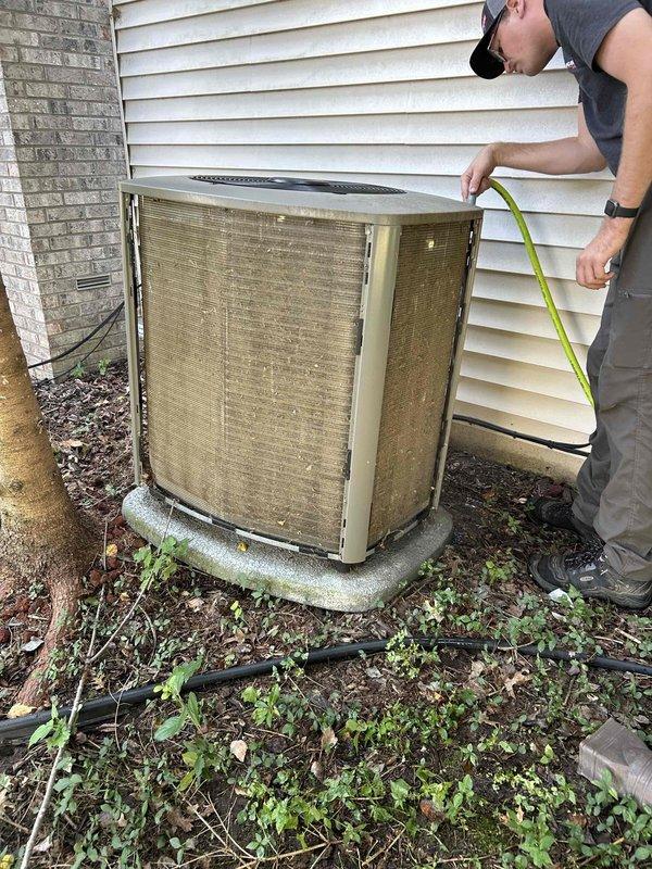 Completed comprehensive preventive maintenance tune-up on both 3-year-old air conditioning and furnace systems per family rewards agreement. Performed full system inspection of outdoor condenser unit, noting accumulated debris and dirt buildup between condenser coil fins that was restricting airflow. Measured unit clearances, inspected electrical connections, and documented unit condition with weathered concrete pad and vegetation encroachment requiring attention for optimal performance.