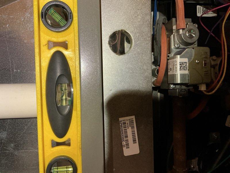 Responded to condensate drainage issue and inspected furnace installation. Upon arrival, accessed condensate trap assembly in extremely tight clearance conditions beneath inducer motor. Performed thorough inspection of trap and surrounding connections for active leaks. Identified evidence of condensation leakage on left side under inducer motor housing. Utilized level to check furnace installation and discovered unit is slightly tilted with right side elevated, causing improper drainage pitch away from condensate trap. Due to severe access restrictions preventing trap replacement or adjustment in current configuration, job requires rescheduling to evaluate alternative solutions including potential furnace releveling or modified trap installation approach to restore proper condensate drainage and prevent water damage.