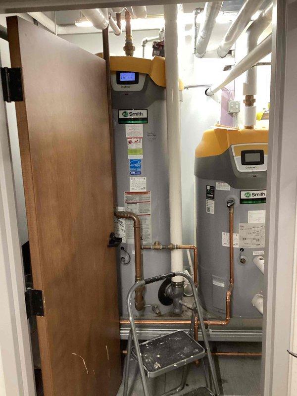 Responded to commercial gas line emergency after utility company tagged multiple leaking fittings including dirt leg cap, tee, and regulator connections on dual water heater system. Shut down water heaters, disassembled affected gas fittings, cleaned and re-doped all leaking joints, then performed bubble test to verify leak-free connections before restoring equipment to service.