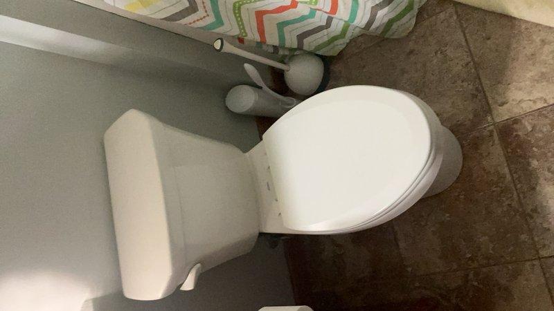 Responded to service call for toilet that was flushing slowly and required holding the handle down for extended periods. Upon inspection, determined that repair was not feasible and proceeded with complete toilet replacement. Removed existing standard-height toilet and installed new comfort height toilet unit. Verified proper flushing operation, checked for leaks at water supply connection and wax ring seal, and confirmed all components functioning correctly upon completion.