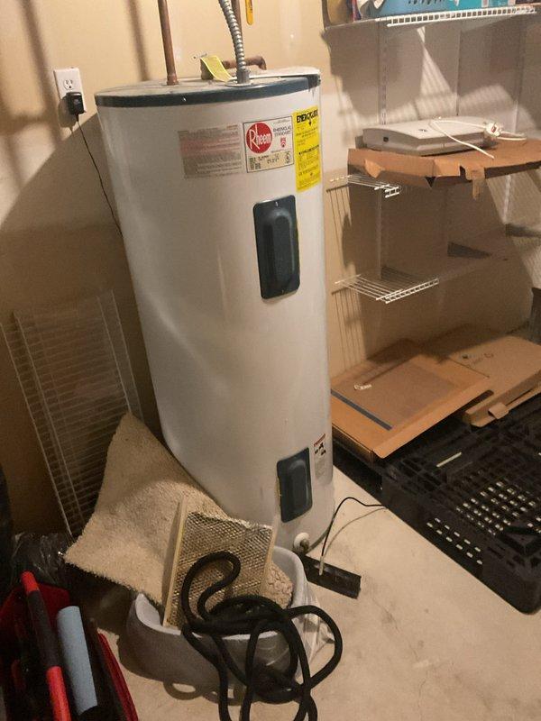 Completed comprehensive plumbing inspection of residential property with focus on water heater and main water supply system. Inspected Rheem water heater unit located in basement utility area, verifying proper installation, connections, and operational status. Examined backflow preventer assembly with dual isolation valves on main water supply line, confirming proper function and compliance with code requirements. Documented all findings with photographs for service records.