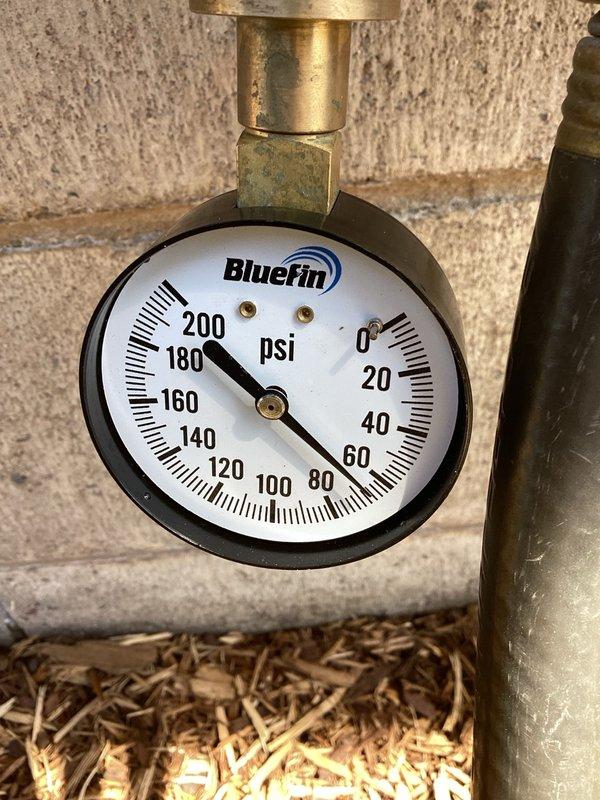 Responded to a no water pressure complaint for a well water system. Upon inspection, measured 70 PSI at the outdoor faucet using a pressure gauge, confirming adequate system pressure. Determined the issue was related to pressure loss through a 100-foot hose being used for lawn watering rather than a system malfunction. Advised customer that the extended hose length was causing significant pressure drop and recommended using a shorter hose or one with larger diameter to improve water flow for lawn irrigation purposes.