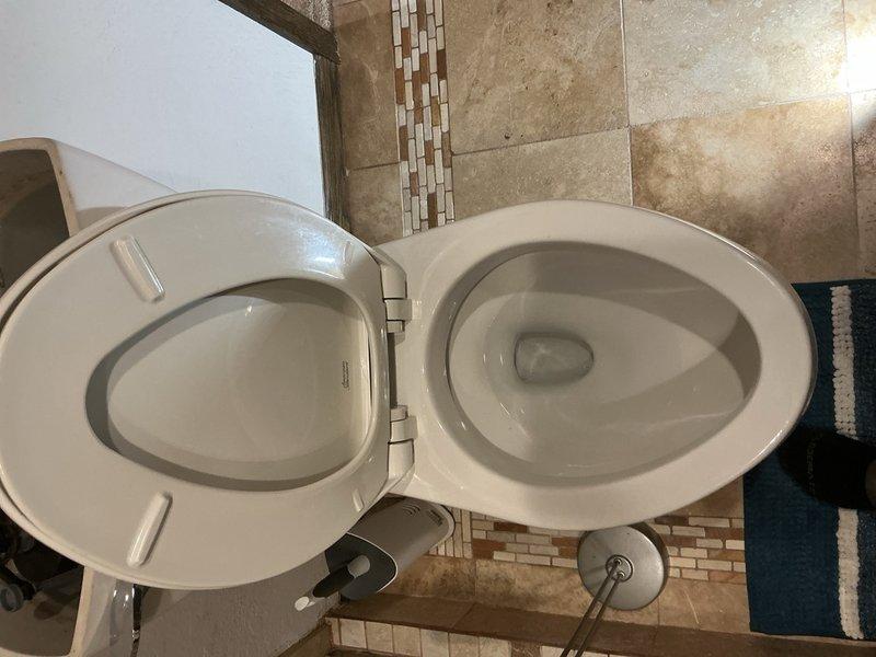 Responded to report of toilet running intermittently. Upon inspection, identified leak in toilet tank caused by improperly adjusted flapper chain. Chain length was excessive, causing it to become caught in the flush valve and preventing proper seal. Shortened flapper chain to appropriate length, tested flush mechanism multiple times to ensure proper operation and complete seal. Verified leak was resolved and toilet now functions correctly with no water waste.