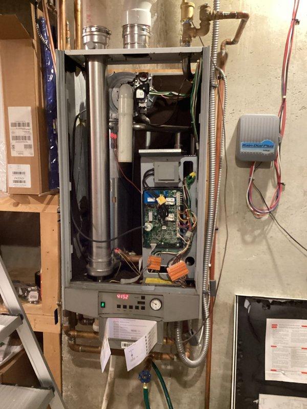 Responded to no heat and no hot water call on a 2009 Triangle Tube Prestige Solo 110 boiler displaying E02 error code indicating ignition failure. Upon inspection, found unit unable to establish ignition and cycle properly. Temporarily achieved ignition by accessing and clearing exhaust vent cap, which indicated restricted venting or heat exchanger fouling. Diagnosed heat exchanger as likely clogged, preventing proper combustion air flow and causing repeated ignition lockouts. Recommended scheduling follow-up service for heat exchanger cleaning or replacement to restore full system operation and prevent continued no-heat conditions.