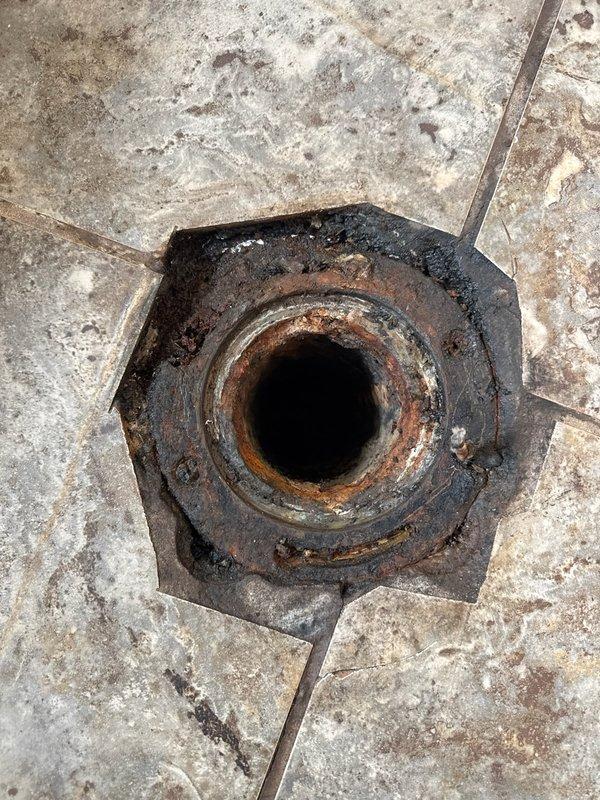 Responded to emergency call for non-functional toilet with active leak. Upon inspection, identified severely corroded cast iron flange as primary failure point, with deteriorated wax ring contributing to water intrusion. Removed existing toilet and assessed subfloor damage around drain opening. Extracted compromised cast iron flange showing extensive rust and structural degradation. Prepared drain opening and installed new toilet flange assembly with proper sealing. Installed new wax ring and reset toilet with new closet bolts, ensuring proper seal and stable mounting. Tested system for leaks and verified proper flush operation before returning unit to service.
