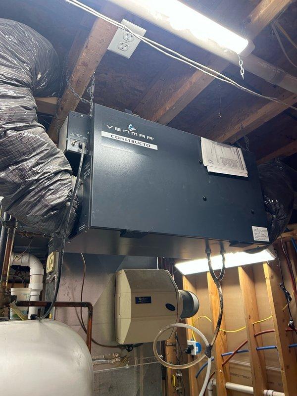 # HVAC Service Completed

Responded to no cooling complaint on one-year-old residential air conditioning system. Upon arrival, performed diagnostic evaluation and confirmed unit was low on refrigerant charge. Conducted comprehensive system verification including temperature split measurements across the evaporator coil and inspected air filtration components. 

Investigation revealed the thermostat was set to cooling mode at 70°F while indoor temperature read 75°F, confirming inadequate cooling performance. Checked furnace control board and found no active error codes present; unit was properly displaying cooling mode operation. Addressed secondary complaint regarding loud noise from furnace area. Identified source of high-pitched sound as coming from the Venmar Constructo ventilation unit installed in the attic space, not the furnace itself.

Inspected attic-mounted HVAC equipment including the ERV/HRV ventilation system, humidifier, and associated ductwork. Verified all mechanical co