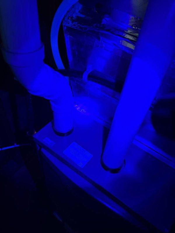 Performed follow-up inspection on R-410A residential air conditioning system with TXV that was previously found frozen and severely starved of refrigerant. Allowed unit adequate time to defrost from previous service call. Conducted diagnostic evaluation using UV leak detection equipment to identify source of refrigerant loss. System had previously exhibited critically high superheat of 56.4°F and negative subcooling of -0.7°F, indicating evaporator was not receiving proper liquid refrigerant flow. Investigated potential causes including refrigerant leak and liquid line restriction, particularly filter-drier obstruction. Documented equipment conditions with photographic evidence showing refrigerant lines, connections, and system components for further analysis and repair planning.