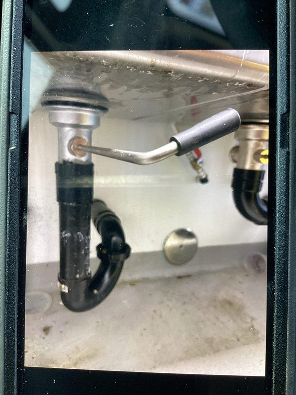 Responded to a commercial sink drain leak caused by a failed basket strainer assembly. Removed the defective strainer and installed a new commercial-grade basket strainer with proper drain assembly connections. Installed chrome drain cover with perforated drainage pattern and connected new P-trap with appropriate rubber couplings to ensure watertight seal. Verified all connections for proper alignment and tested the complete drain system for leaks under full water flow. Cleaned and inspected the work area upon completion. All components functioning properly with no leaks detected. One-year parts and labor warranty provided on installation.