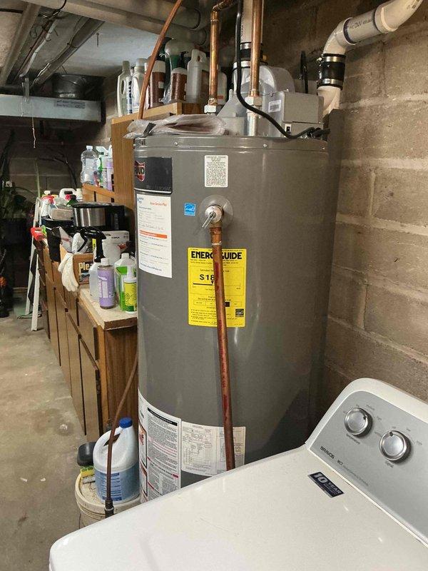 Completed annual heating maintenance inspection on 1-year-old furnace and boiler system. Replaced plugged furnace filter with customer-provided filter to restore proper airflow. Inspected boiler venting and exhaust stack for condensation issues following previous installation, noting water drainage concerns on PVC vent piping. Verified furnace exhaust venting is operating properly with no abnormalities detected. Documented equipment condition with photographs of mechanical room showing water heater, HVAC components, PVC venting infrastructure, and refrigerant lines with filter drier.