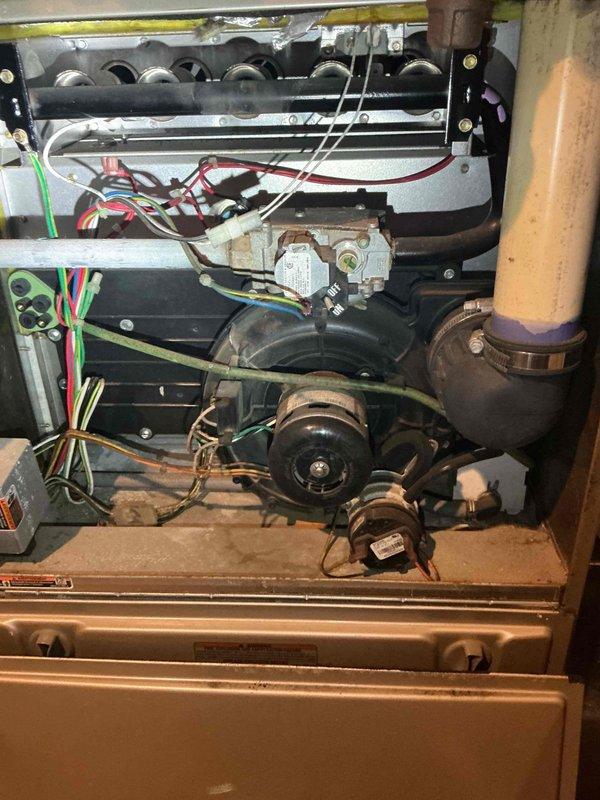 Responded to no cooling call on 13-year-old Carrier central air conditioning system. Upon inspection, discovered the contactor had physically failed at the bottom terminal, causing the wire to detach and create a short circuit that burned the electrical whip. Assessed the damaged whip and determined insufficient wire length remained for proper repair, requiring complete whip replacement along with contactor replacement. Performed compressor winding resistance testing across all terminals to evaluate potential compressor damage from the electrical short. Found resistance readings were approximately equal across all windings, indicating probable compressor damage has occurred. Documented findings with photos of furnace installation and internal mechanical compartment showing electrical connections and components. Reviewed all repair and replacement options with homeowner and coordinated scheduling with service advisor for system evaluation and recommendations.