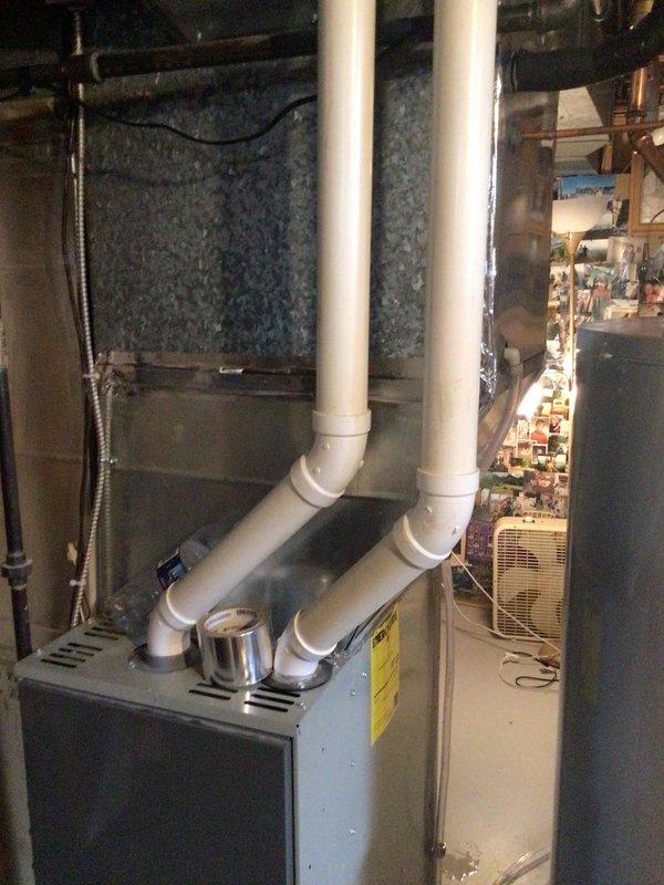 Responded to no-cool call on 1-year-old ICP system with reported water leakage pooling in furnace and overflowing onto floor. Upon inspection, discovered evaporator coil had tilted backward, preventing proper condensate drainage from the drain pan. Installed shim screw underneath coil assembly to adjust pitch forward, restoring proper drainage angle. Verified condensate now flows correctly through drain line without pooling or overflow. System operating normally with no further leakage observed.