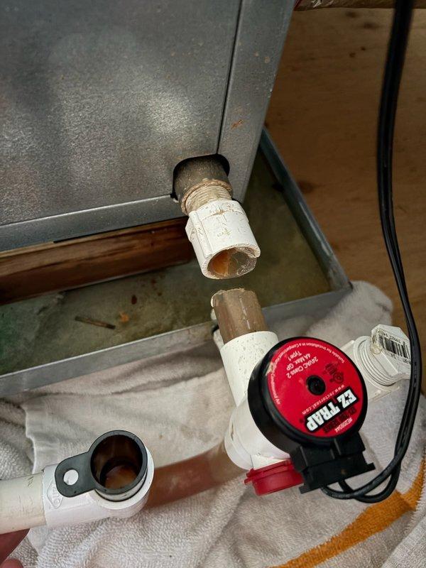 Responded to report of water accumulation in drip pan beneath condenser and air handler located in third-floor attic. Upon inspection, identified broken condensate trap causing improper drainage. Removed defective trap assembly and installed new PVC trap with proper configuration to ensure adequate drainage and maintain proper air seal. Verified system operation and confirmed condensate draining correctly with no leaks.
