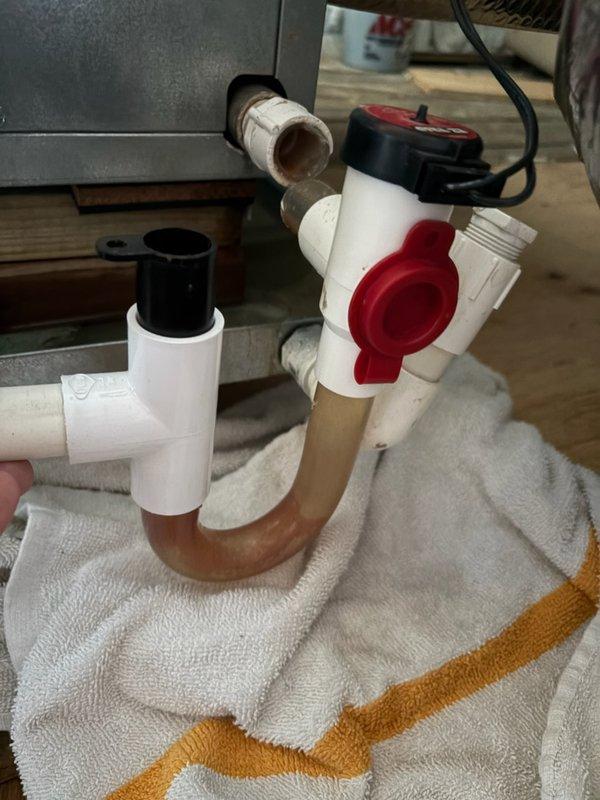 Responded to report of water accumulation in drip pan beneath condenser and air handler located in third-floor attic. Upon inspection, identified broken condensate trap causing improper drainage. Removed defective trap assembly and installed new PVC trap with proper configuration to ensure adequate drainage and maintain proper air seal. Verified system operation and confirmed condensate draining correctly with no leaks.