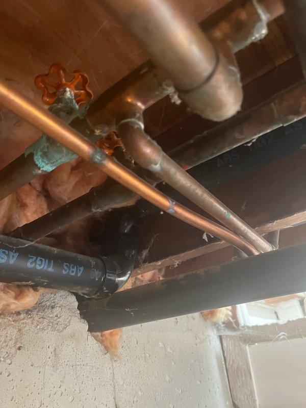 Responded to emergency plumbing call for active water leak in basement. Upon inspection, identified pinhole leak in copper water supply line running through exposed ceiling joists. Shut off water supply to affected section using existing shutoff valve. Removed damaged section of copper piping showing signs of corrosion and age-related deterioration. Installed new copper pipe section with properly soldered joints and fittings to replace compromised piping. Pressure tested repaired section to ensure leak-free operation. Restored water service and verified no additional leaks present in surrounding plumbing infrastructure.