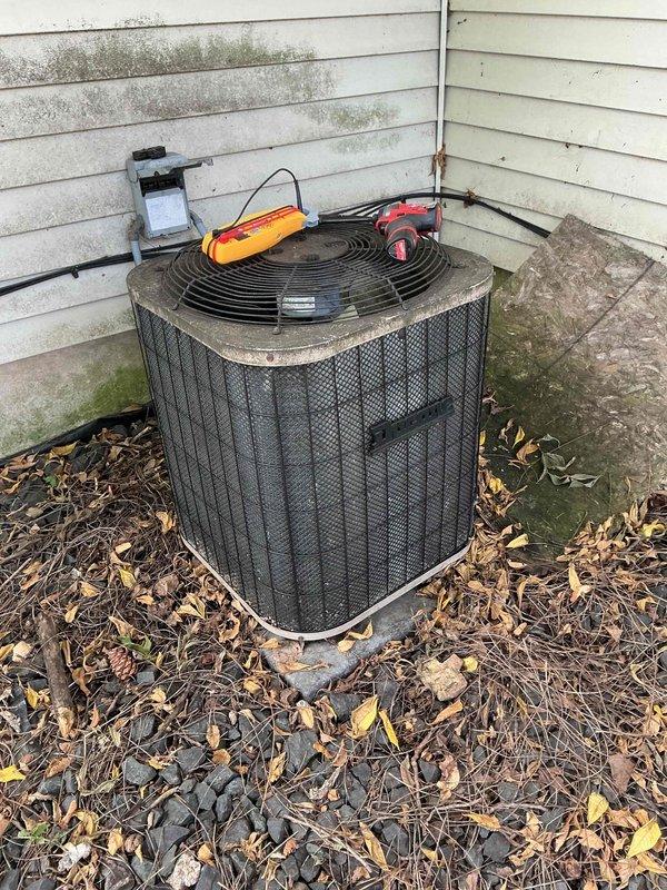 Responded to no cooling call on 10+ year old air conditioning system. Found thermostat calling for cool with indoor blower operating, but outdoor condenser unit humming and not starting. Diagnosed failed capacitor preventing compressor and condenser fan motor operation. Replaced defective capacitor with new dual run capacitor, rinsed outdoor coil to remove debris accumulation, and verified system startup. Unit now operating properly with normal cooling cycle restored.