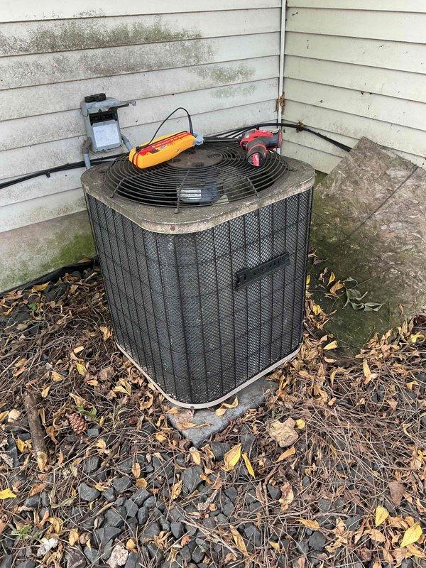 Responded to no cooling call on 10+ year old air conditioning system. Found thermostat calling for cool with indoor blower operating, but outdoor condenser unit humming and not starting. Diagnosed failed capacitor preventing compressor and condenser fan motor operation. Replaced defective capacitor with new dual run capacitor, rinsed outdoor coil to remove debris accumulation, and verified system startup. Unit now operating properly with normal cooling cycle restored.