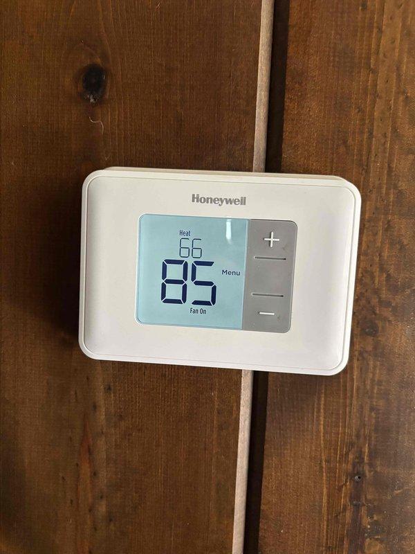 Performed annual heating and cooling maintenance inspection on residential HVAC system. Verified thermostat operation and confirmed proper 24V signal to all components. Inspected air filter and advised homeowner that correct filter size is 14x25x1 rather than the currently installed 16x25x1. During operational testing, discovered that while heating and cooling functions were engaging, the blower motor failed to operate. Conducted diagnostic testing and verified 24V power supply to blower motor was present and within normal parameters. Upon physical inspection of blower assembly, found blower wheel completely seized and unable to rotate. Diagnosed failed blower motor as root cause of system malfunction. Recommended complete blower motor replacement to restore full system functionality. Documented findings with photographs of thermostat display and electrical panel. Advised that annual preventative maintenance procedures will need to be rescheduled following completion of blower motor re