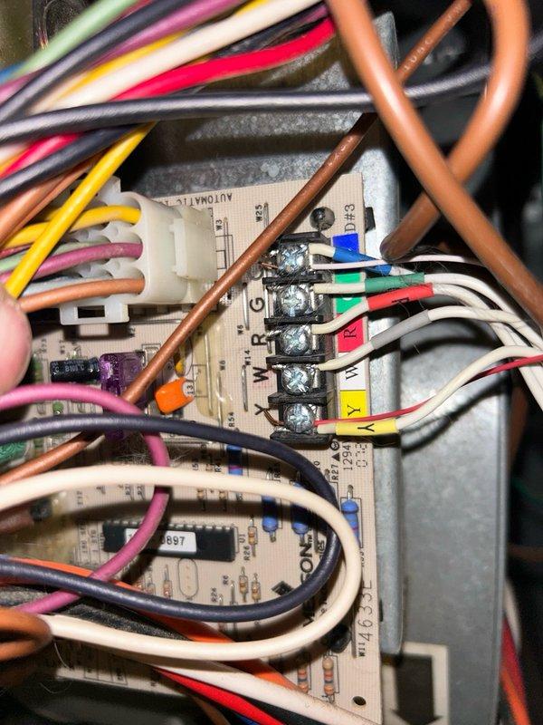 Responded to callback for air conditioning system not cooling. Performed diagnostic testing on thermostat control circuit and identified intermittent failure of Ecobee PEK (Power Extender Kit) module causing loss of cooling call. Confirmed indoor and outdoor equipment functionality by manually jumping R to Y terminals at air handler control board, verifying low voltage cooling circuit operational. Observed thermostat experiencing multiple power dropout cycles before stabilizing, isolating fault to PEK module rather than HVAC equipment. Documented control board wiring configuration and existing thermostat wire limitations. Presented repair options including standard thermostat replacement or installation of new 5-conductor thermostat cable with dedicated common wire to eliminate PEK module dependency. Customer approved installation of new thermostat wiring to resolve intermittent failure issue. Photographed existing ductwork configuration in basement utility area and control board termi