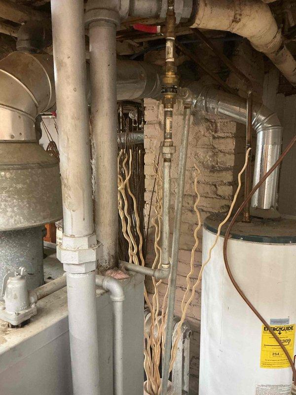 Arrived on-site for scheduled boiler tune-up and inspection at duplex property with two boiler units. Upon arrival, discovered unit had no electrical power supply. Inspection revealed exposed electrical wiring creating immediate safety hazard, along with exposed asbestos insulation material on piping systems requiring professional abatement. Due to multiple safety violations and lack of power to equipment, unable to proceed with standard tune-up procedures including combustion analysis, burner inspection, or operational testing. Documented all hazardous conditions with photographic evidence showing corrugated asbestos-wrapped piping, compromised electrical connections, and overall system configuration. Property owner advised that licensed electricians were scheduled to address power and wiring issues. Recommended that electrical repairs be completed first, followed by professional asbestos abatement before any further HVAC service work can be safely performed on either boiler unit.