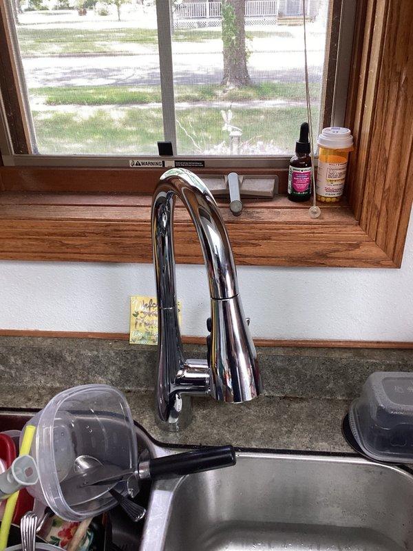 Responded to service call for leaking garbage disposal under kitchen sink. Upon inspection, determined that the kitchen faucet had reached end of useful life and was the source of the leak. Removed old failing faucet assembly and installed new chrome pull-down kitchen faucet with modern curved spout design. Verified proper water supply connections, tested for leaks, and confirmed full functionality of new fixture. All components sealed and operating correctly upon completion.
