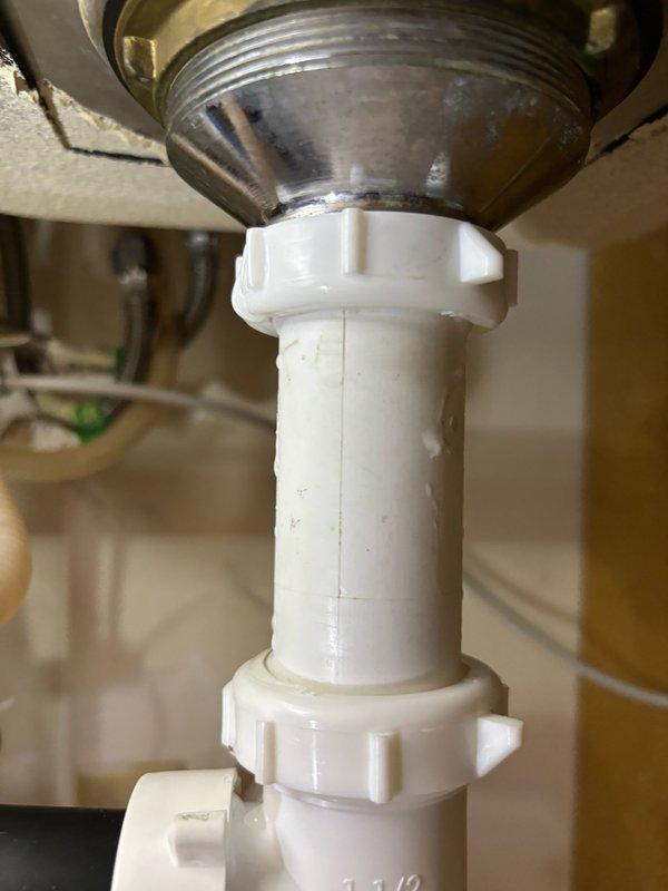 Responded to callback for leak under kitchen sink following previous garbage disposal service. Upon inspection, discovered the coupling nut on the sink strainer basket was deformed and failing to create a proper seal. Removed the defective nut and installed a new replacement coupling nut on the strainer basket assembly. Tightened all connections to manufacturer specifications and performed a thorough leak test by running water through the system for five minutes. No leaks were detected during testing. Verified all drain connections were secure and left the sink fully operational and in service.