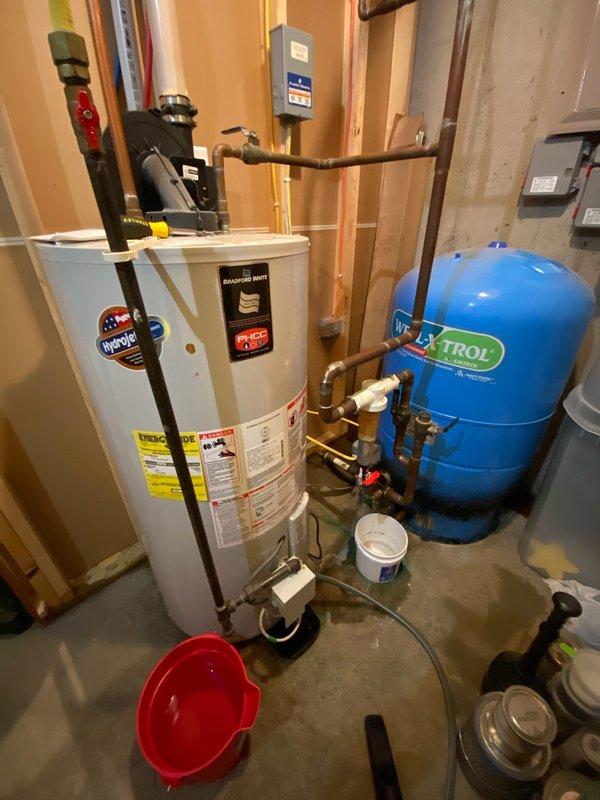 Responded to service call for non-functional water heater with confirmed leak in residential basement. Upon arrival, unit had already been drained by customer. Performed assessment and confirmed water heater was beyond repair due to active leak. Removed existing failed tanked water heater including disconnection of copper supply lines, hot water outlet piping, and all associated fittings. Installed new replacement tanked water heater in same location, securing unit with proper metal strapping per code requirements. Connected copper piping to inlet and outlet ports using appropriate brass fittings and compression connections. Verified proper integration with existing EXTROL expansion tank and pressure relief system. Tested all connections for leaks, filled tank, and restored hot water service to residence. Cleared work area and removed old unit from premises. System operational and performing to manufacturer specifications upon completion.