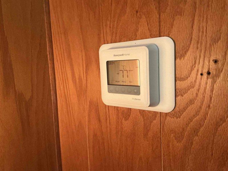 Responded to no cool call on 3-year-old system. Upon arrival, found Honeywell Home ProSeries thermostat removed from wall mount following battery replacement by homeowner. Verified thermostat settings were correct, reinstalled unit onto wall mount, and powered system on. System initiated after standard five-minute delay period and cooling cycle engaged properly. Cycled system through heating mode to verify full functionality, then retested cooling operation with successful results. Provided homeowner education on hardwired thermostat operation, clarifying that unit must remain mounted on wall for proper system communication. All functions operating normally at completion.