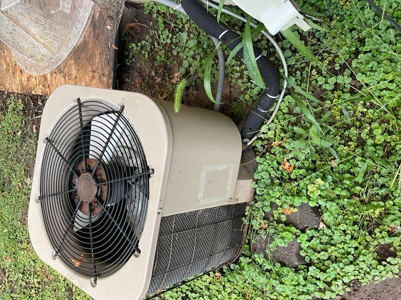 Responded to no-cooling complaint on ThermalZone outdoor condensing unit at residential property where new homeowner reported system failed to reach setpoint after initial 8-hour operation. Performed diagnostic evaluation on unit with missing model/serial data plate, preventing exact age verification. Measured incoming voltage at 246V and tested dual run capacitor rated 30/5 µF, which measured 29.5/5 µF within acceptable tolerance. Verified all wiring connections to compressor and condenser fan motor. Upon thermostat call for cooling, observed condenser fan motor energized but fan blade assembly exhibited extreme stiffness requiring manual assistance to rotate, indicating failed condenser fan motor with seized bearings rather than capacitor failure. Advised homeowner that unit appears to be legacy R-22 equipment based on age and configuration, complicating repair decisions due to refrigerant obsolescence. Discussed implications of planned backyard project requiring potential condenser 