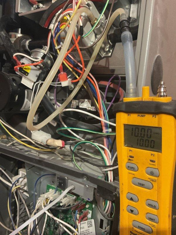 Performed annual maintenance on dual HVAC systems including two furnaces, two air conditioners, two humidifiers, and air exchanger. Adjusted gas manifold pressures on both furnaces from 11" to under 10" water column to manufacturer specifications. Corrected excessive temperature rise on main floor furnace from 75°F to 60°F by increasing blower speed; upstairs unit operating at acceptable 55°F rise. Replaced both 16x20x1 filters and verified flame sensor operation at approximately 50 ohms. Installed missing combustion box blocker plate in manifold that was omitted during original installation. Checked subcooling and superheat on both air conditioning units and documented with photos. Identified incorrect 24V wiring on both humidifier controls; recommended contacting original installer for warranty correction as units are less than one year old. Observed oil accumulation on refrigerant lines at press fittings on left AC unit, indicating potential refrigerant leak requiring follow-up insp