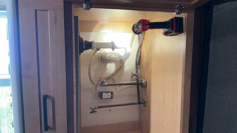 Reinstalled kitchen sink following new countertop installation and completely reconfigured the drain piping system beneath the sink. Replaced and properly aligned all PVC drain connections, installed new mounting hardware, and ensured proper venting and drainage flow to meet plumbing code requirements.
