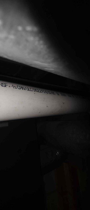 Responded to service callback to document PVC exhaust piping installation for inspector review. Photographed Schedule 40 PVC exhaust pipe showing proper NSF-rated materials and routing through mechanical space. Captured detailed images of complete mechanical room installation including ductwork, copper plumbing lines with brass fittings, water heater connections, and pump assembly to verify code-compliant installation and provide documentation for approval process.