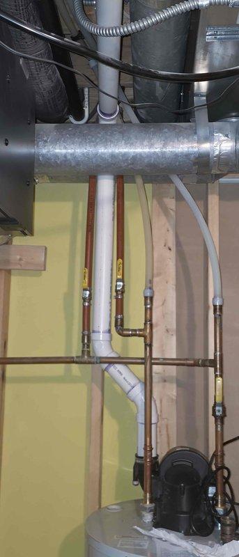Responded to service callback to document PVC exhaust piping installation for inspector review. Photographed Schedule 40 PVC exhaust pipe showing proper NSF-rated materials and routing through mechanical space. Captured detailed images of complete mechanical room installation including ductwork, copper plumbing lines with brass fittings, water heater connections, and pump assembly to verify code-compliant installation and provide documentation for approval process.