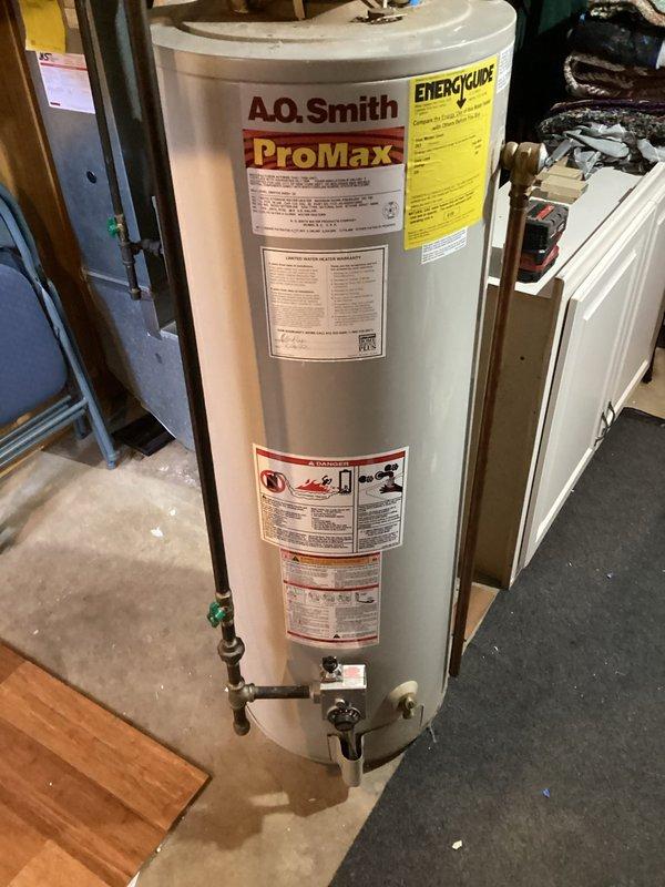 Responded to emergency call for back drafting 40-gallon natural gas water heater. Upon inspection, identified 24-year-old A.O. Smith ProMax unit experiencing dangerous combustion gas spillage due to inadequate makeup air in utility room. Immediately shut off gas supply to unit for safety. Assessed draft hood and flue system, confirming improper venting conditions caused by insufficient fresh air supply. Implemented temporary solution by opening window to provide makeup air and prevent carbon monoxide hazard. Documented flue conditions and water heater installation with photographs. Advised that permanent ventilation solution required and recommended unit replacement due to age and safety concerns.